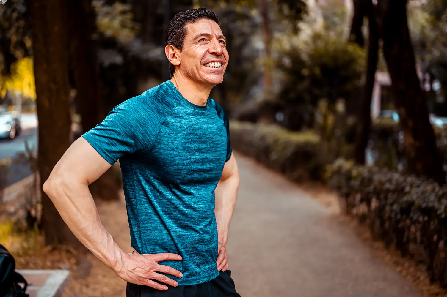 older man pausing to enjoy the sun during a run