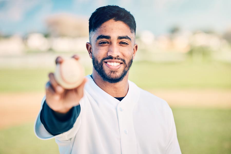 professional baseball player smiling and holding baseball